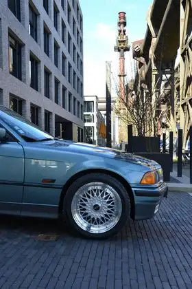 Berline BMW Série 3 2001, extérieur bleu turquoise métallisé avec jantes BBS argentées.