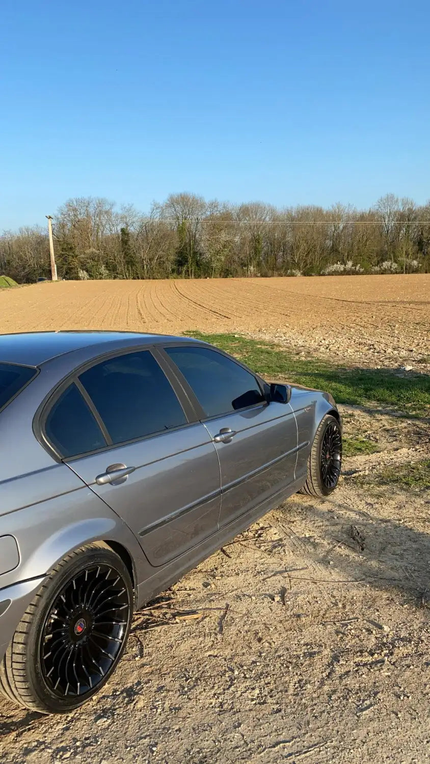Berline BMW Série 5 2013 avec jantes noires et carrosserie argentée.