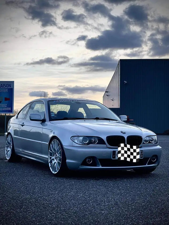 Coupé BMW Série 3 argenté avec jantes en alliage et calandre à damier.