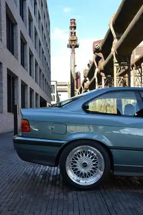 Coupé BMW Série 3 turquoise des années 1980 avec jantes fil d'argent.