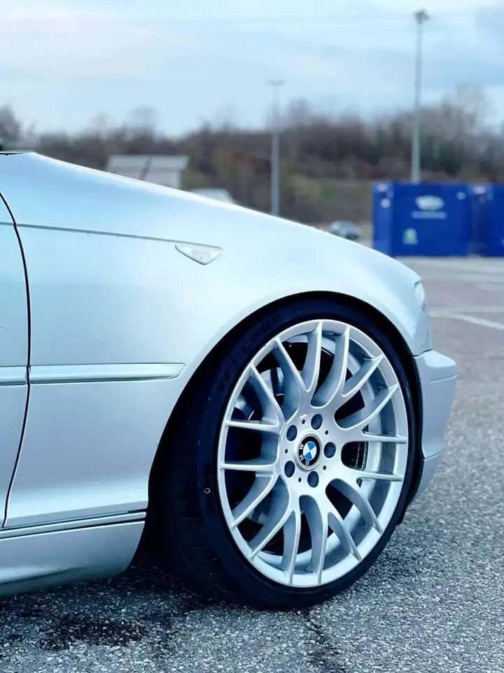 Roue BMW argent avec design à multiples branches et pneu noir.